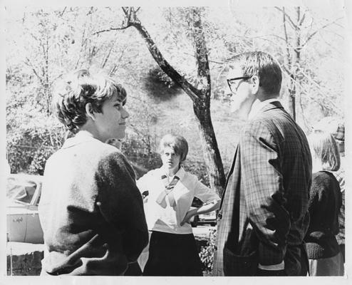 Unidentified students standing outside and conversing with each other