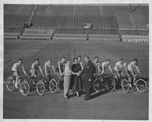 James Beazley (shaking hands) and Carolyn Collier (center) looking at 