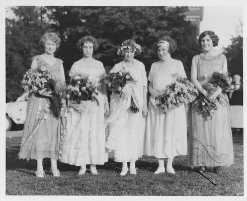 Five women in dresses with bouquets of flowers