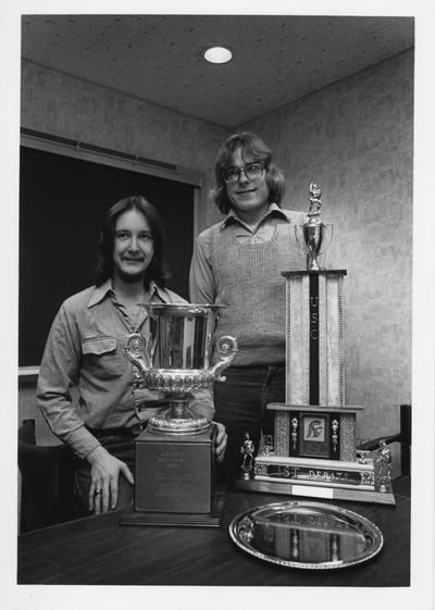 Mr. Skillman (left) and Mr. Oberst (right) are standing with three trophies