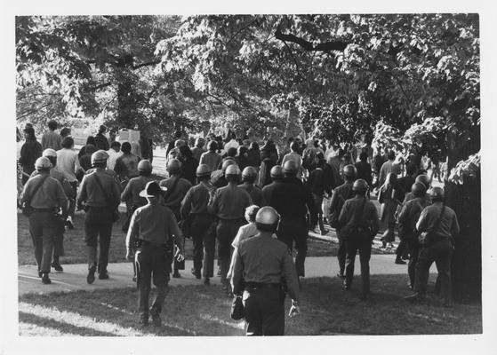 Armed guards follow the crowd of protesters during a reaction to the Kent State shootings