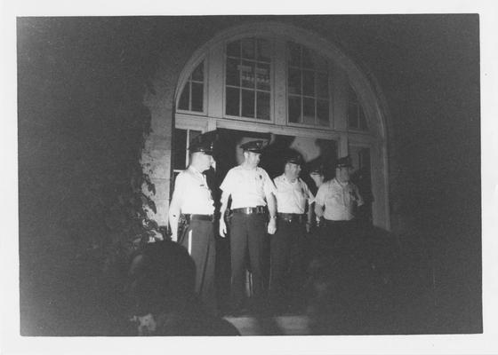 Police officers stand in the doorway of Barker Hall during a protest in reaction to the Kent State shootings