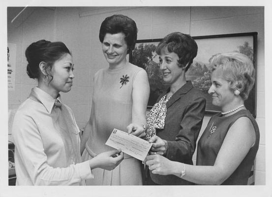 University of Kentucky Woman's Club makes a donation to the Nell Donovan International Student Loan Fund; Standing, left to right: Estella Fendley, University of Kentucky Assistant Foreign Student Advisor; Mrs. Robert Kiser, University of Kentucky Woman's Club; Mrs. Daniel S. Arnold, University of Kentucky Woman's Club Treasurer; Mrs. William Peters, University of Kentucky Woman's Club