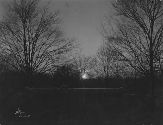 A cannon near the Administration building with sunrise or sunset in background; This is in the 1920 Kentuckian on page 12, image 1; Photographer: White Studio