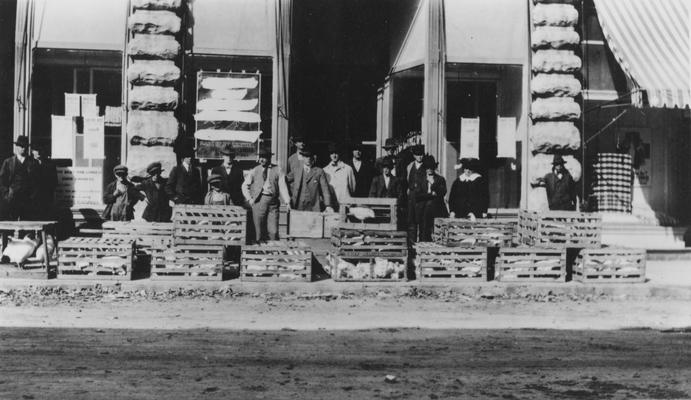 People standing alongside crates of chickens on a roadside