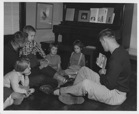 Men reading to a group of children