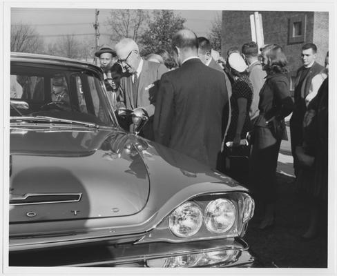 Drivers' Education students stand beside a car