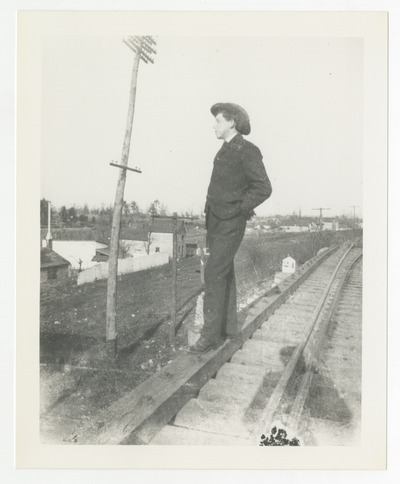 Young man posing on railroad tracks