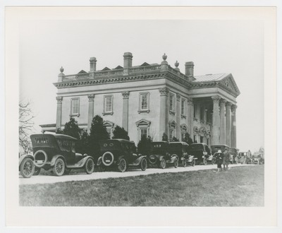 Unknown house with line of cars in driveway