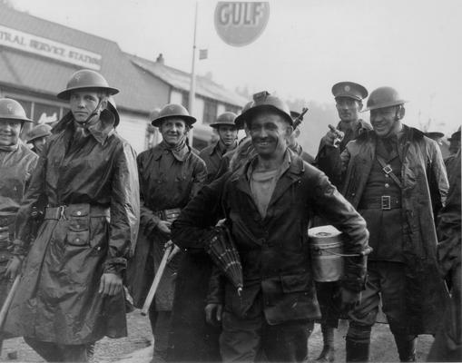 A grinning miner surrounded by National Guardsmen