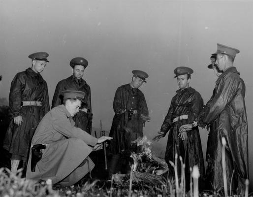 National Guardsmen around an outdoor fire