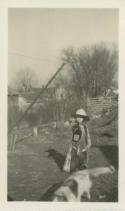 young boy dressed as a cowboy and a dog