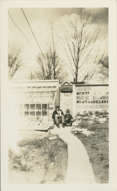 boy and a man sitting outside a gate