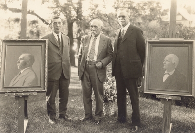 H. E. Curtis, Alfred M. Peter and C. W. Matthews posed with painted portraits of both Dr. Robert Peter and Alfred Peter on the occasion of Alfred M. Peter's 70th birthday