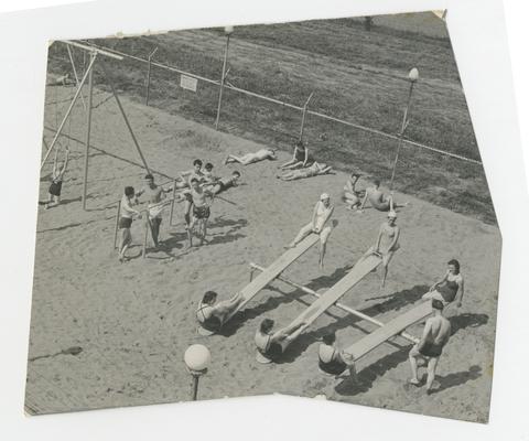 People lounging on playground wearing swimsuit, girls sitting on seesaws, boys leaning against bars, Joyland Park, Lexington, Kentucky