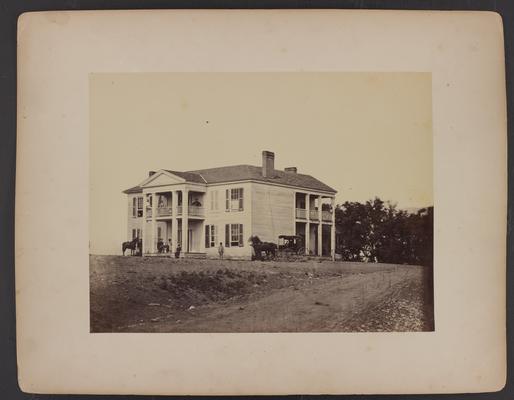 The Oliver Perry House, also known as the White House, the house is a large white wooden sided building with two floors and columns, there are various African-Americans siting on upstairs and downstairs porches, Caucasian man in military uniform sitting on porch, horse, and horse and buggy in front of house, dirt road in foreground, with trees in the background