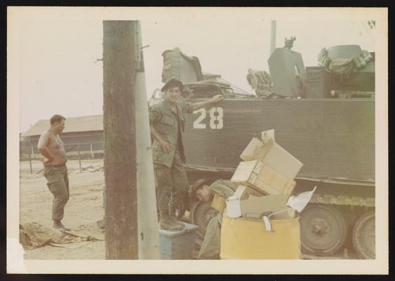 Joe Parisi next to armored personnel carrier in base camp