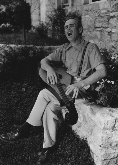 John Jacob Niles outdoors at Boot Hill Farm accompanying himself with dulcimer; National Geographic