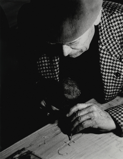 John Jacob Niles painting the doors which he carved for St. Hubert's Church; Helm Roberts