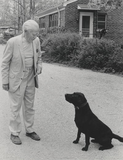 John Jacob Niles outdoors with dog Rosie; Boot Hill Farm; Cincinnati Enquirer