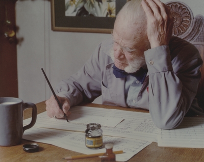 John Jacob Niles working on a music manuscript at dining room table, Boot Hill Farm; Steve Mitchell
