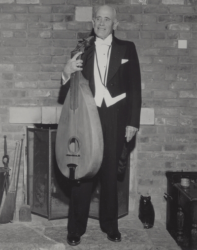 John Jacob Niles in evening dress with dulcimer, posed at Boot Hill Farm; Jack Cobb