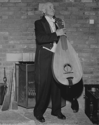 John Jacob Niles in evening dress with dulcimer, posed at Boot Hill Farm; Jack Cobb