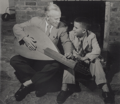 John Jacob Niles with son Tom seated in front of fireplace; Boot Hill Farm; Van Deren Coke