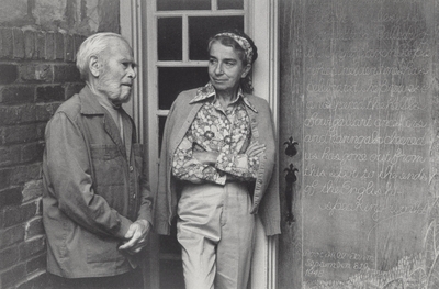 John Jacob Niles and Rena Niles beside carved door at Boot Hill Farm; Biff LeVee