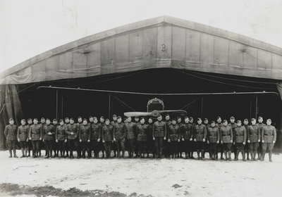 Group of World War I soldiers in front of airplane hangar, John Jacob Niles (front row, far right)