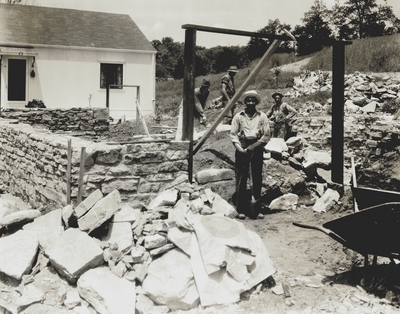Robert Hicks, foreground, workman on Niles' home.  Background: John Jacob Niles (left) and Claude Snowden (right) and his son; Boot Hill Farm; Kenneth Studio