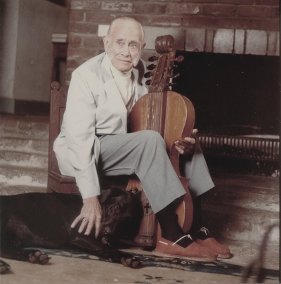 John Jacob Niles holding dulcimer and petting Rosie; Boot Hill Farm