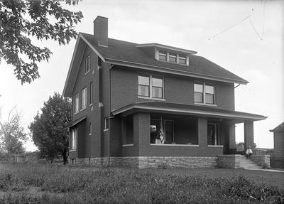 exterior of a house, a man sitting on porch steps