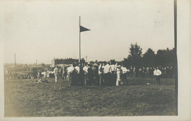 flag with people gathered around circa 1910