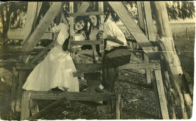 Man and woman sitting at the bottom of a wooden structure  circa 1914