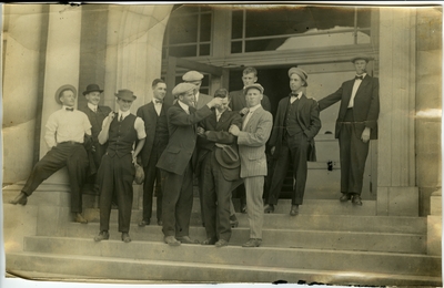 Group of 11 men standing on the steps of a building circa 1914