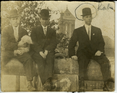 3 men sitting on a cannon on UK's campus circa 1914