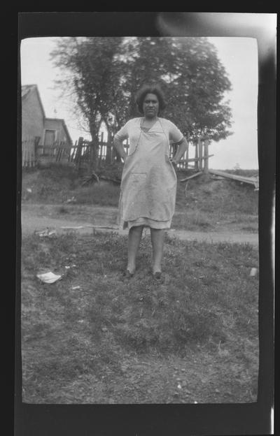 Negative of unidentified woman in yard