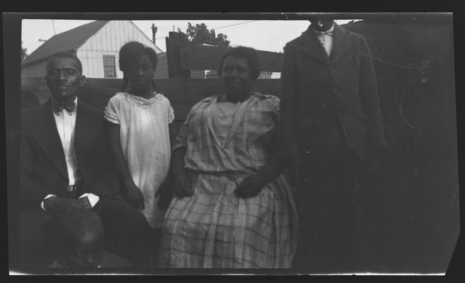 Negative of two unidentified men and two women, one man's head is cut out of frame