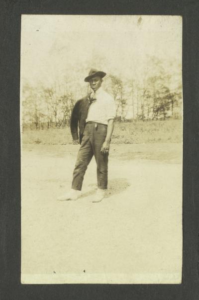 Page 6 [R]: Unidentified black man with coat hanging off one shoulder