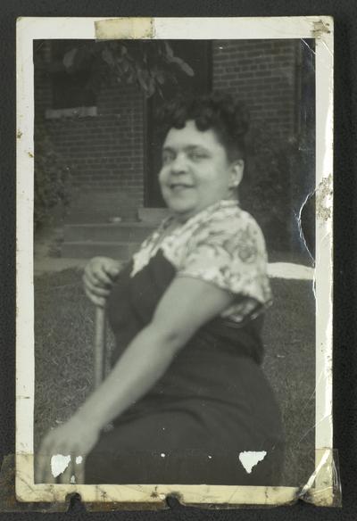 Floella (Browning) Harris sitting on a chair in a yard