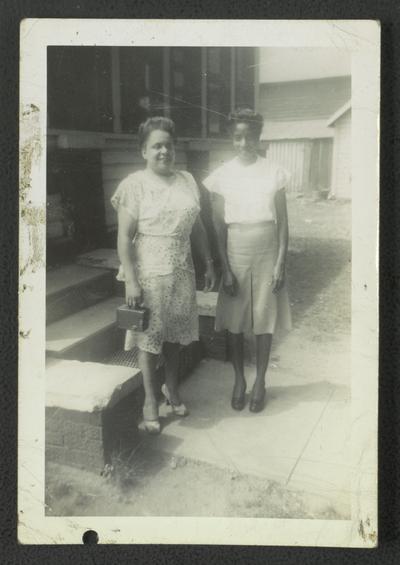 Mrs. Floella B. Harris [L] and an unidentified woman [R] in front of house