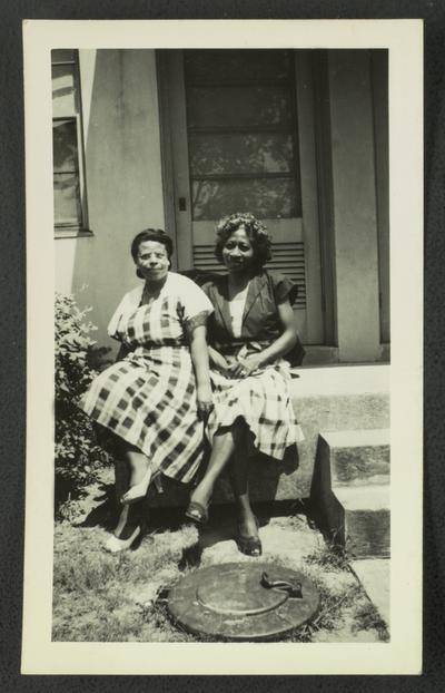 [L to R] Mary Alice Warren and unidentified woman sitting on steps