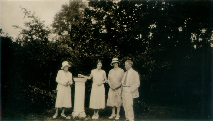 Mary Shelby Wilson, two woman, and a man standing by a sun dial