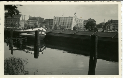 Boat on the water with buildings in background  