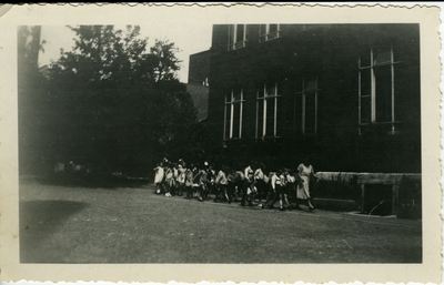 Woman and group of children outside  