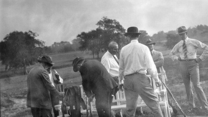 Group of men at a fish fry and shoot, several guns