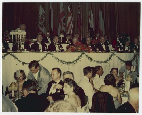 Chief Justice Vinson, front row of dais above crowd