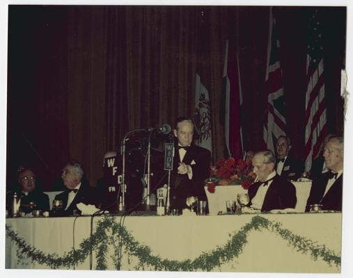 Speaker at microphones on front row of dais