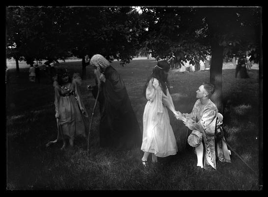 Pageant, play, young man kneels to maiden